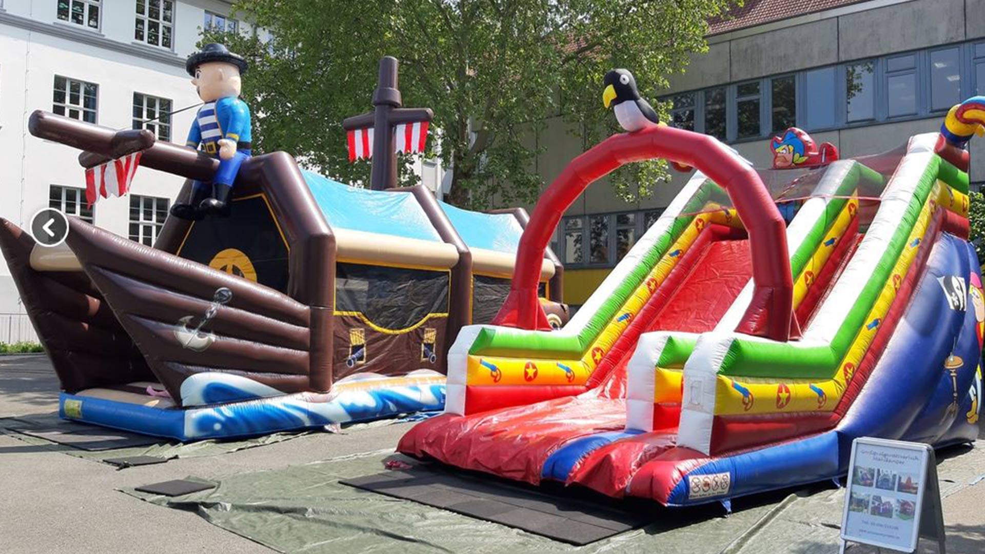 Aufgebaute Hüpfburg in Piratenschiff-Optik mit Rutsche für Kinder bei einem Outdoor-Event